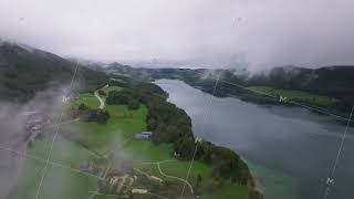 Low clouds are hovering over the trees and fields surrounding the Fuschlsee in the Austrian Alps [upl. by Oulman681]