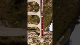 Landwasser viaduct a birds eye view as a Swiss train passes through train switzerland drone [upl. by Ern]