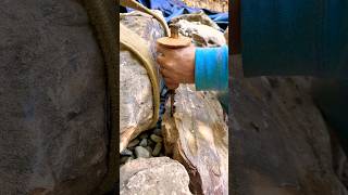 Chiseling a rock to make the perfect fit riverbedbuilders gardendesign pondbuilders [upl. by Ehtyaf]