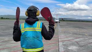 The aircraft marshaller is signaling the ATR72 plane to taxi to the airport ramp [upl. by Massab608]