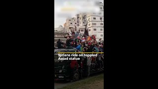 Syrians ride on toppled Assad statue  AJ shorts [upl. by Letsirk]