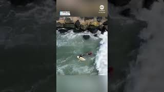 Surfers rush to rescue fishermen knocked off jetty [upl. by Cumine]