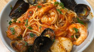 Italian Seafood Pasta with Scallops Calamari Shrimp Clams and Mussels in a savory tomato sauce [upl. by Enillebyam]